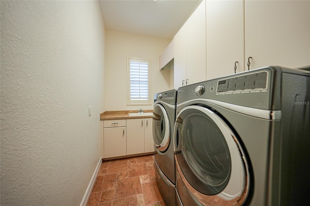 washroom featuring cabinets, washer and clothes dryer, and sink