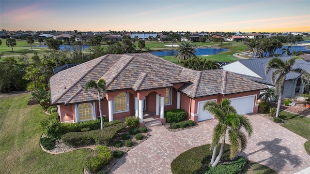 view of front of house with a garage and a water view