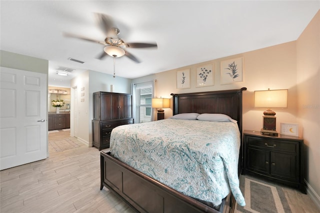 bedroom featuring ceiling fan, ensuite bath, and light hardwood / wood-style flooring