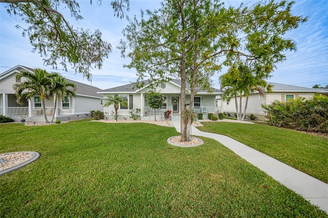 ranch-style home featuring covered porch and a front lawn