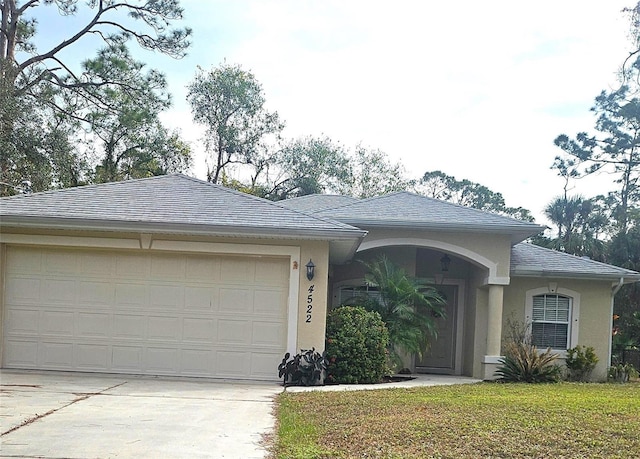 ranch-style house featuring a front lawn and a garage