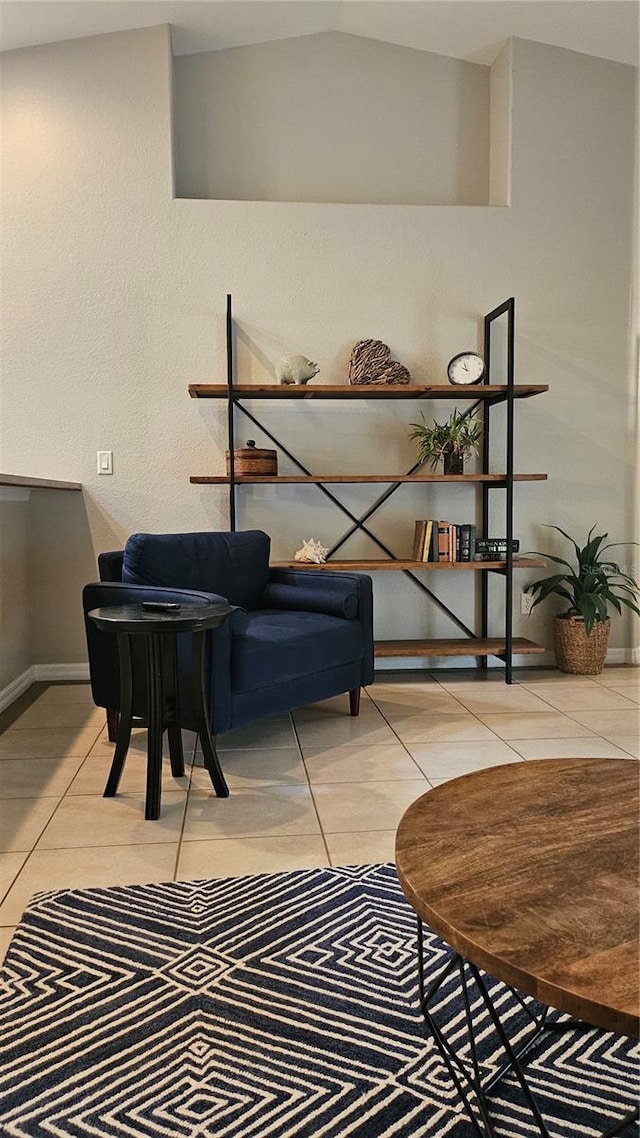 living area with light tile patterned floors and lofted ceiling