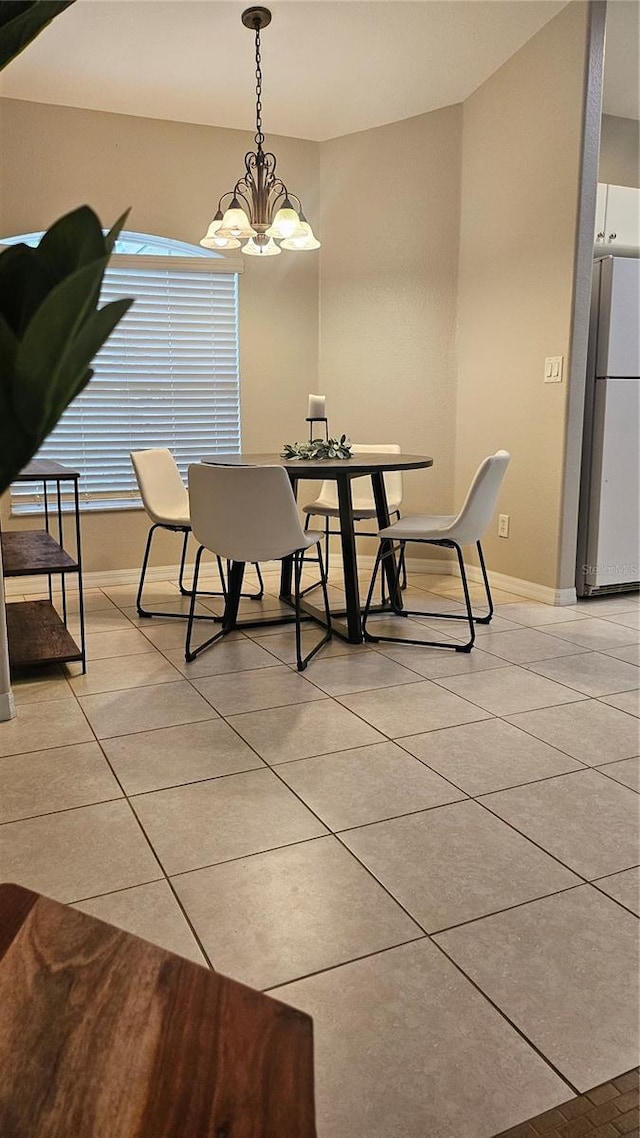 tiled dining space featuring a chandelier