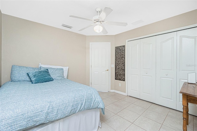 bedroom with ceiling fan, light tile patterned floors, and a closet