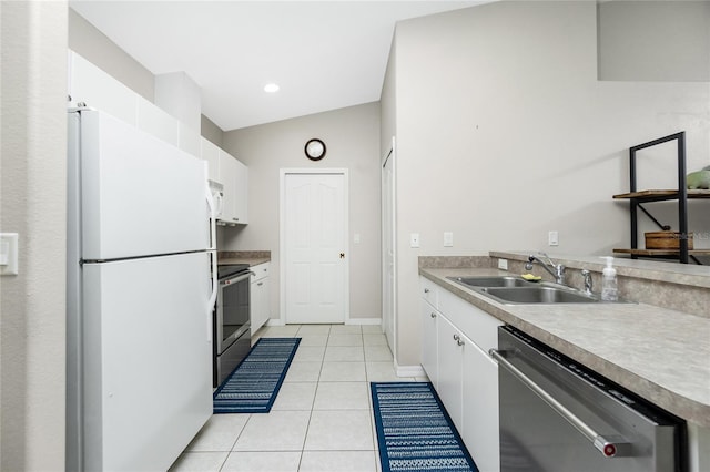 kitchen with light tile patterned flooring, appliances with stainless steel finishes, white cabinets, and sink