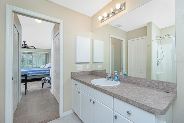 bathroom featuring walk in shower, vanity, ceiling fan, and tile patterned floors