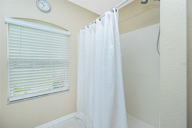 bathroom with walk in shower and tile patterned floors