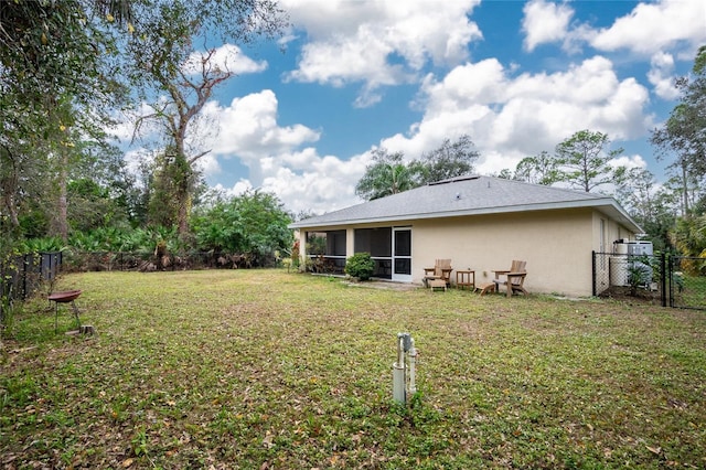 back of house with a yard and a sunroom