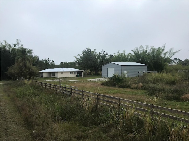 view of yard with a rural view, a garage, and an outdoor structure