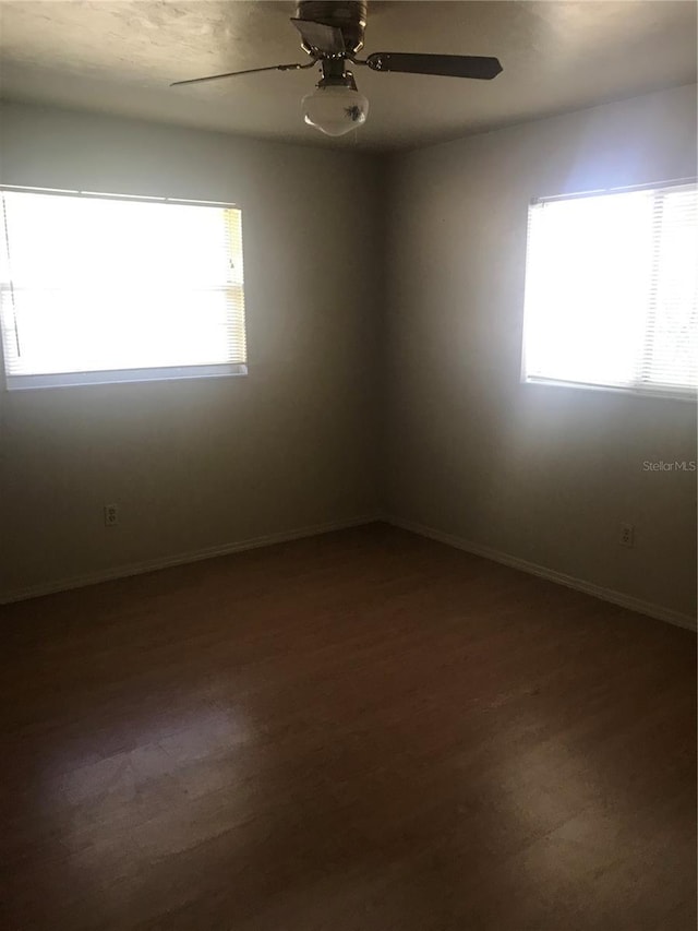 spare room with wood-type flooring, a wealth of natural light, and ceiling fan