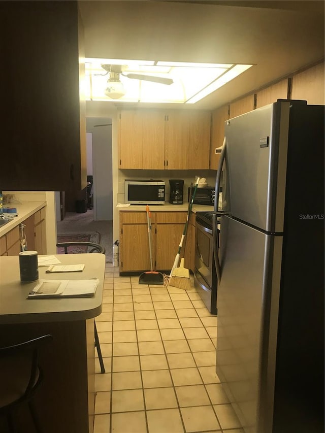 kitchen featuring stainless steel appliances and light tile patterned floors