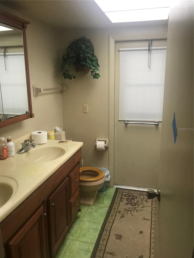 bathroom with tile patterned flooring, vanity, and toilet