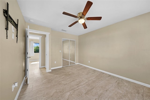 unfurnished bedroom featuring ceiling fan and a closet