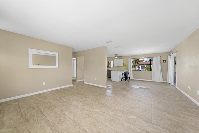 unfurnished living room with a notable chandelier