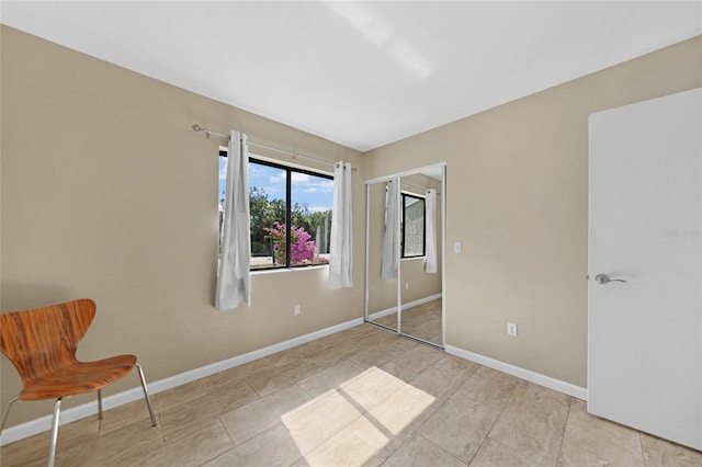 unfurnished bedroom featuring light tile patterned floors and a closet