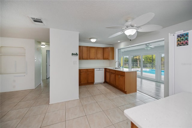 kitchen featuring ceiling fan, light tile patterned floors, dishwasher, and kitchen peninsula