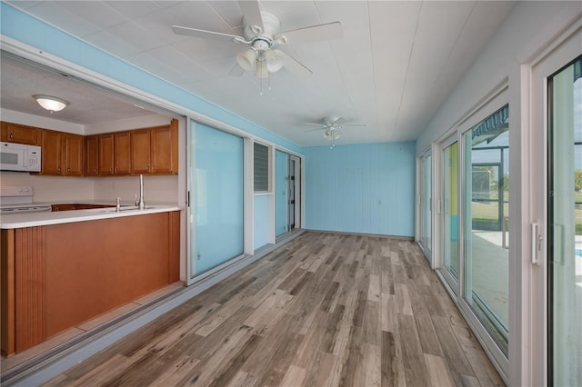 kitchen featuring ceiling fan, white appliances, and light hardwood / wood-style flooring