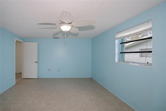 empty room featuring a textured ceiling and ceiling fan