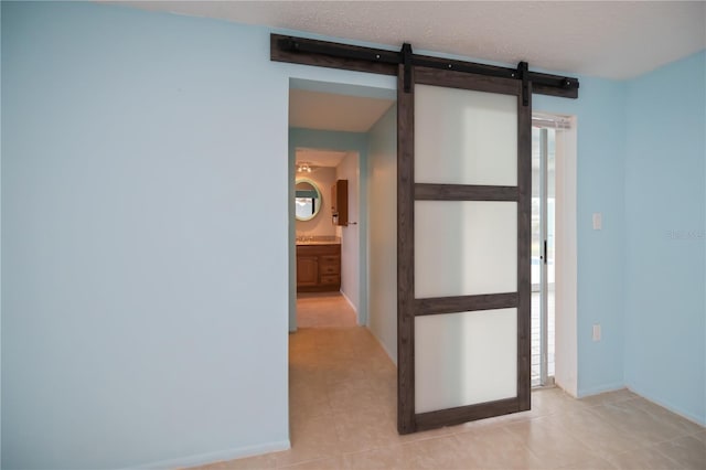 tiled spare room with a barn door and plenty of natural light