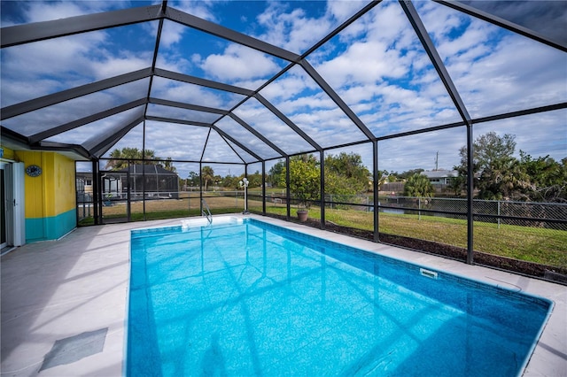 view of swimming pool featuring glass enclosure, a patio area, and a yard