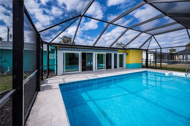 view of swimming pool with glass enclosure and a patio area