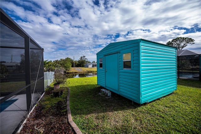 view of outbuilding with a water view and a yard