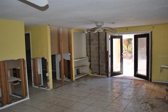 interior space with ceiling fan, french doors, and a textured ceiling