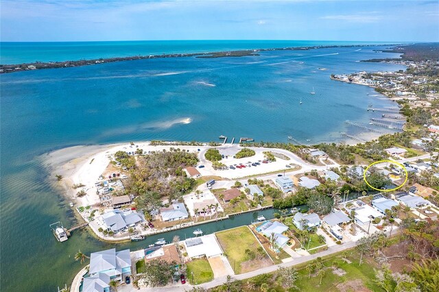 birds eye view of property with a water view and a beach view