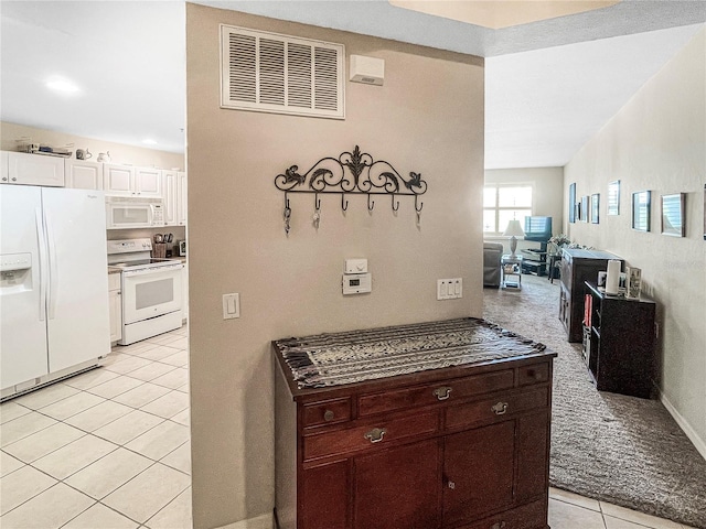 kitchen featuring white cabinets, light tile patterned floors, white appliances, and dark brown cabinetry