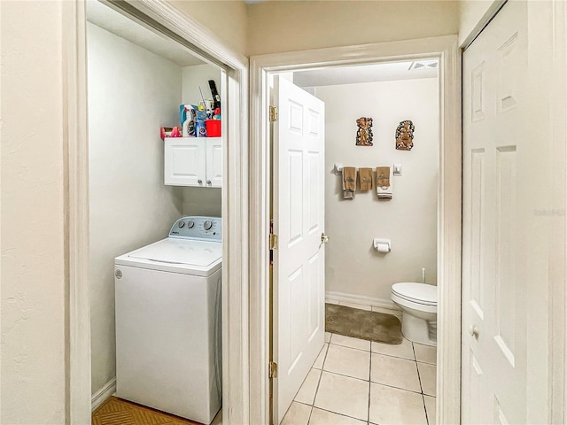 clothes washing area with cabinets, light tile patterned floors, and washer / clothes dryer