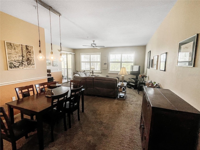 dining space featuring ceiling fan, a textured ceiling, and dark colored carpet