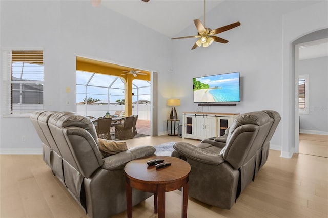 living room with high vaulted ceiling and light wood-type flooring