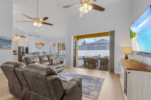 living room with light hardwood / wood-style floors, plenty of natural light, and high vaulted ceiling