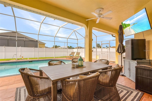 view of patio with a lanai, ceiling fan, and a fenced in pool