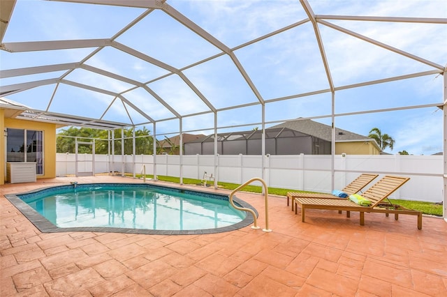 view of swimming pool featuring glass enclosure and a patio