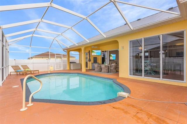 view of pool with glass enclosure and a patio area