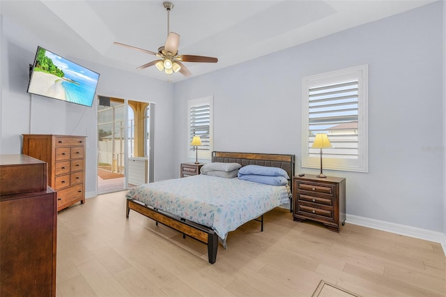 bedroom featuring ceiling fan, light hardwood / wood-style floors, and ensuite bath