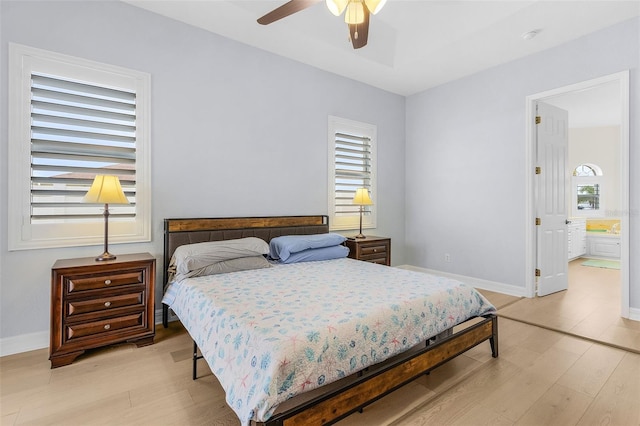 bedroom featuring ceiling fan, light hardwood / wood-style floors, and ensuite bath