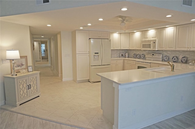 kitchen featuring white appliances, tasteful backsplash, sink, kitchen peninsula, and ceiling fan