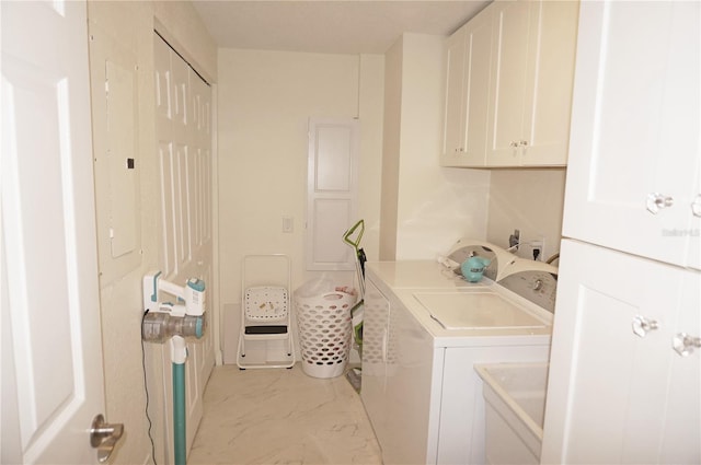 clothes washing area featuring washing machine and dryer, cabinets, and electric panel