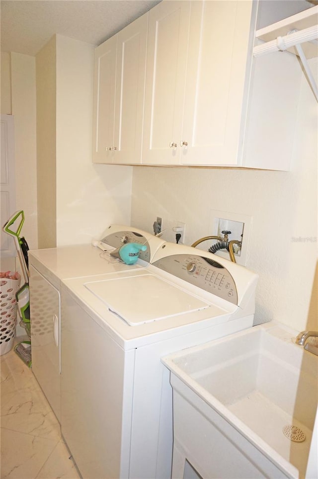 washroom featuring sink, independent washer and dryer, and cabinets