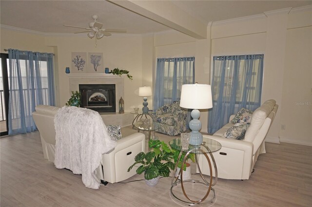 living room featuring ceiling fan, beam ceiling, ornamental molding, and light hardwood / wood-style floors