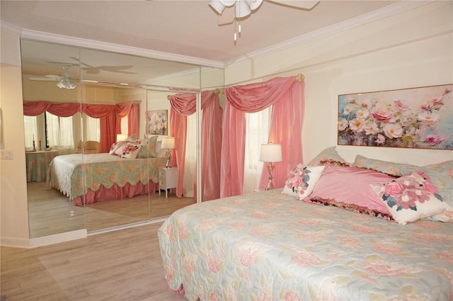 bedroom with ceiling fan, hardwood / wood-style flooring, a closet, and ornamental molding