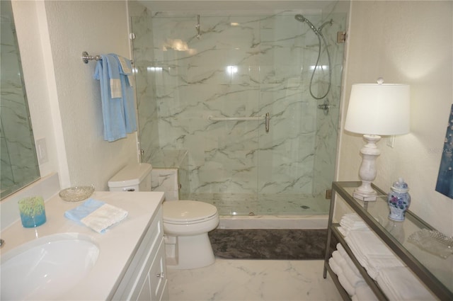 bathroom featuring toilet, vanity, and a shower with door