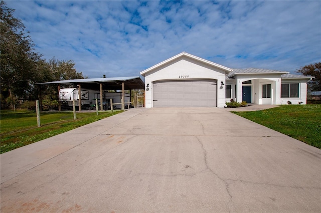 view of front of property featuring a front lawn, a garage, and a carport