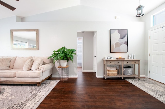 living room featuring vaulted ceiling, dark wood-type flooring, and ceiling fan with notable chandelier