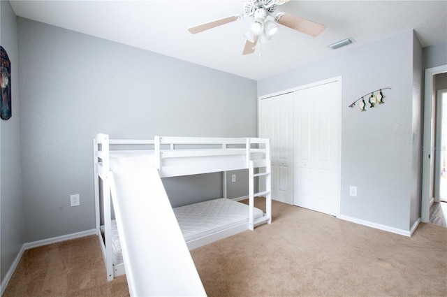 unfurnished bedroom featuring ceiling fan, light colored carpet, and a closet