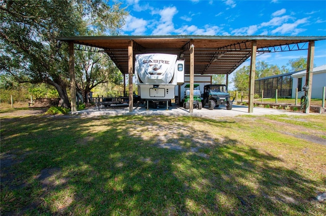 view of parking / parking lot with a carport and a yard