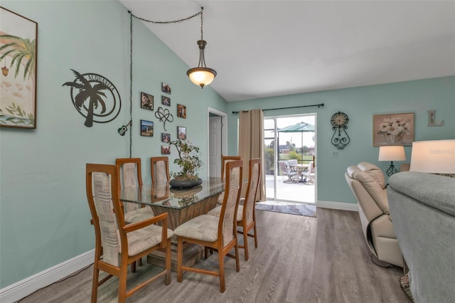 dining room with vaulted ceiling and hardwood / wood-style floors