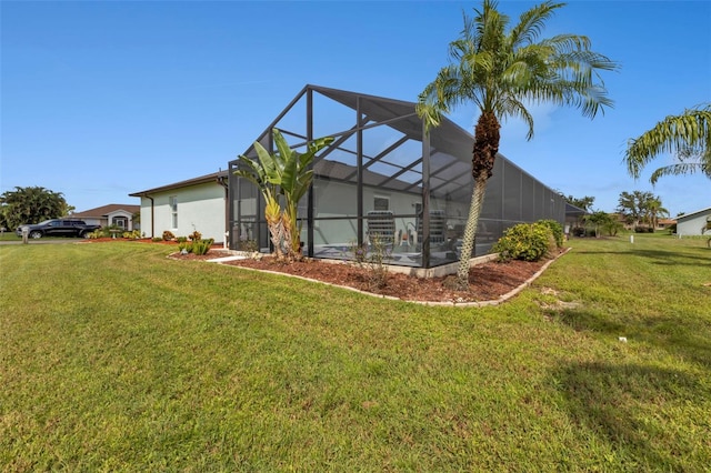 back of house featuring glass enclosure and a yard